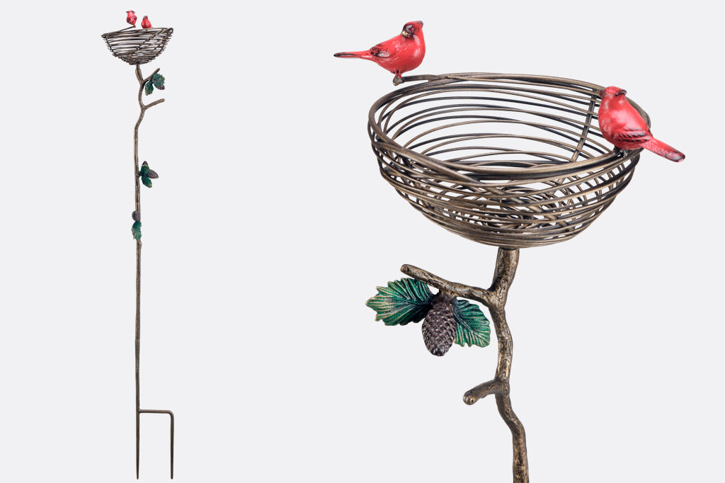 staked planter with red cardinals and a pine branch and pinecone motif adorns a decorative bird nest intended to hold a potted plant