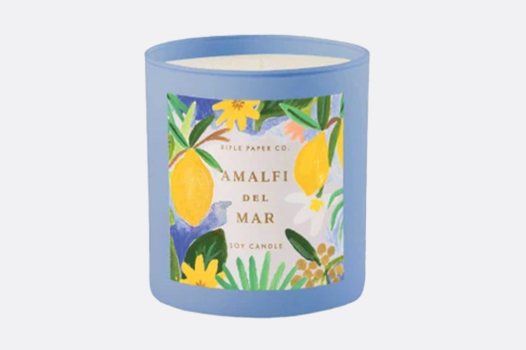 candle in blue lass container with lemon illustrations label