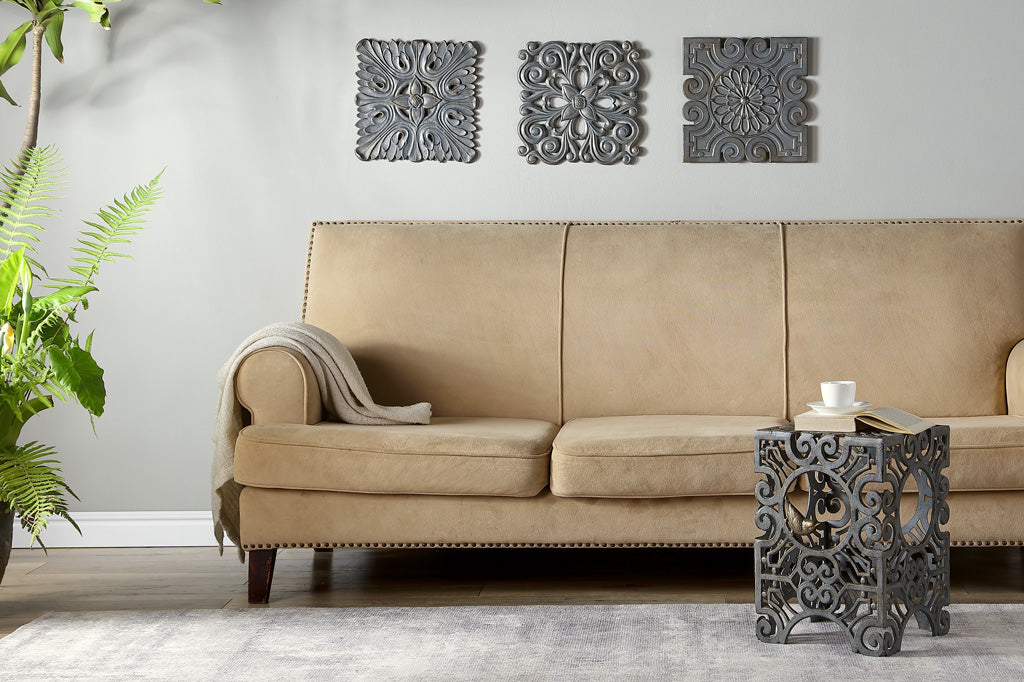 Beige sofa in a living room with decorative wall art and a side table.