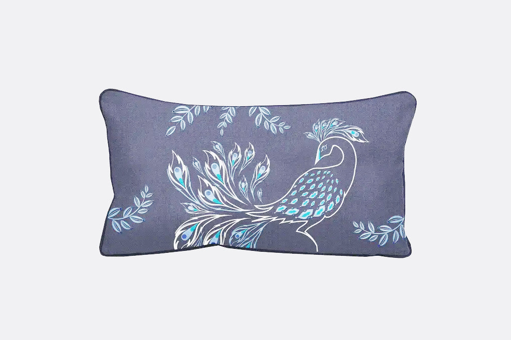 Denim color outdoor fabric pillow embroidered with a peacock in celery green and vivid blue 