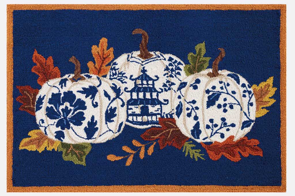 Hooked wool rug with blue and white chinoiserie style pumpkins and autumn leaves on a blue background