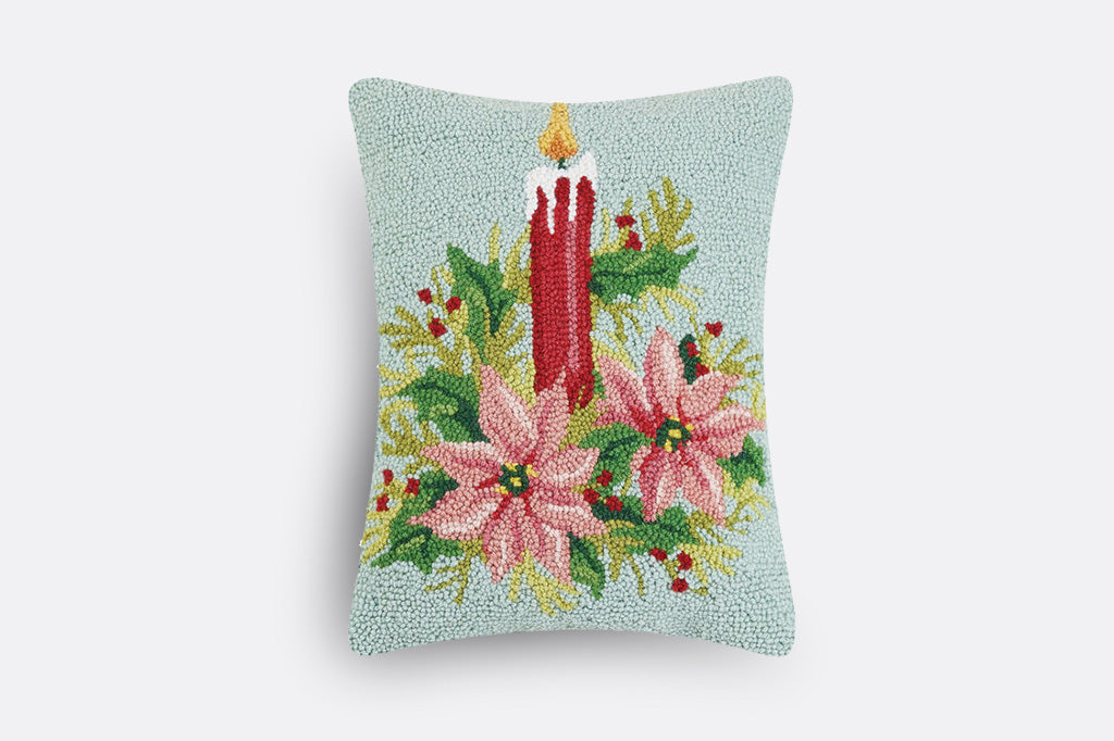 hooked wool pillow with pastel holiday scene of candle and poinsettias