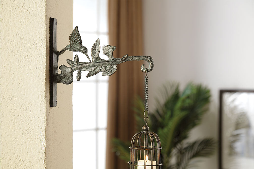 Left side of Hummingbird Mounted Hanger shown in a house holding a votive candle lantern