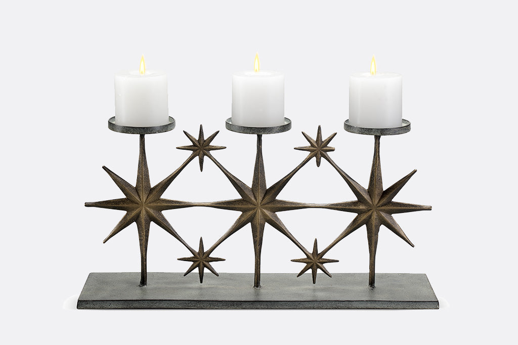 metal candleholder with large star motifs holding three candles 
