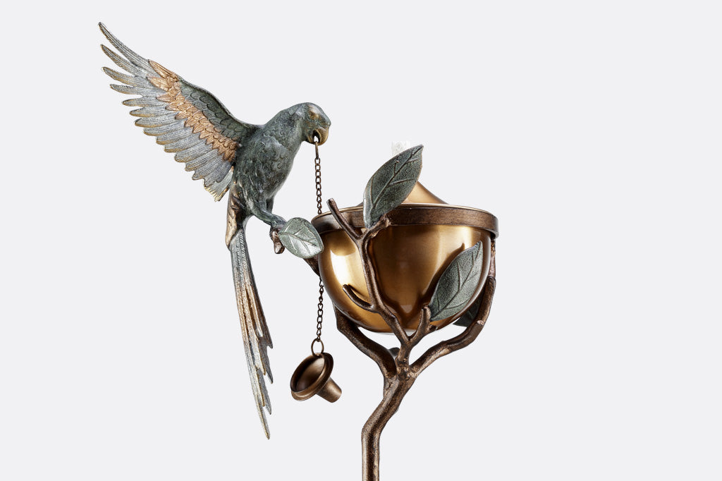 Outdoor Garden Torch with parrot on a leafy branch. Wings outstretched.