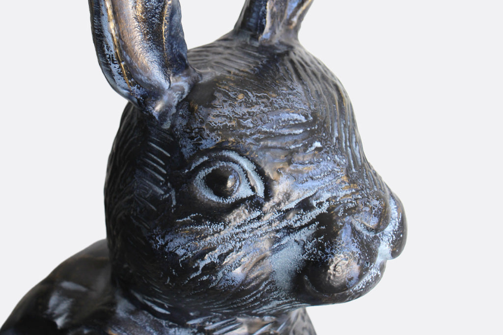 Black metal bunny sculpture with blue and bronze highlights