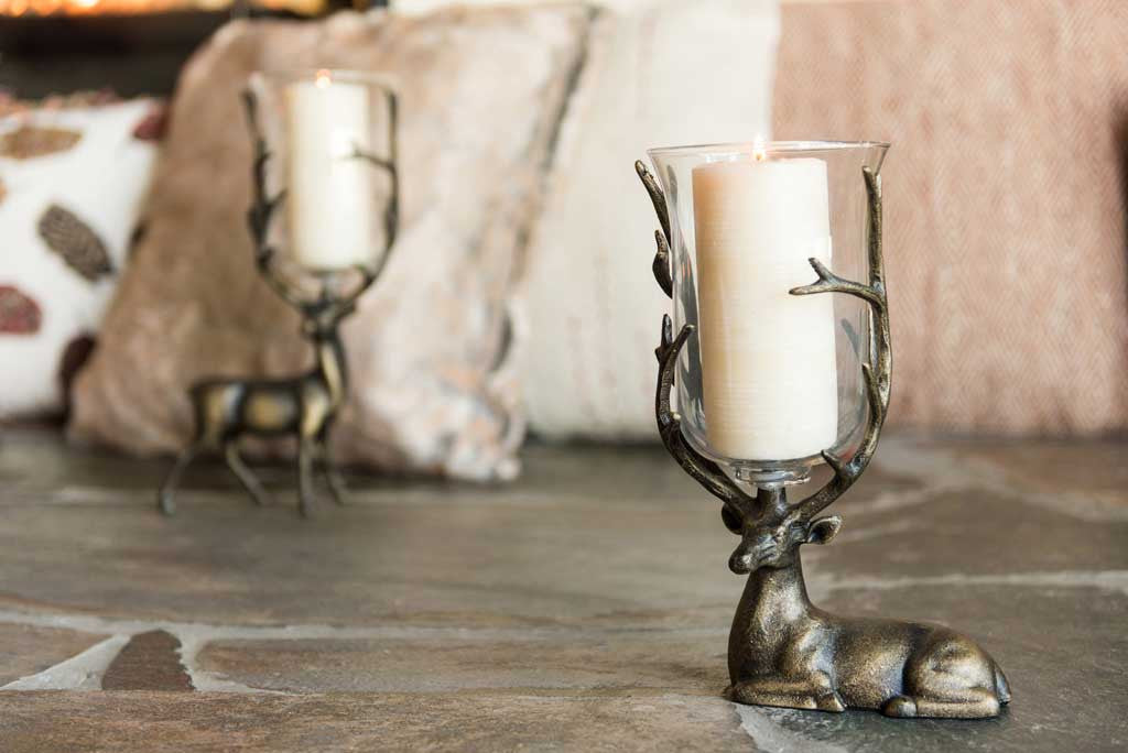 two deer candleholders hold pillar candles in glass