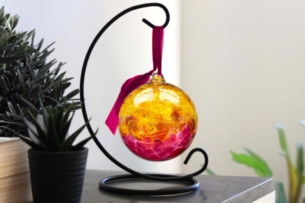 Handblown glass ornament designed to hang from metal stand