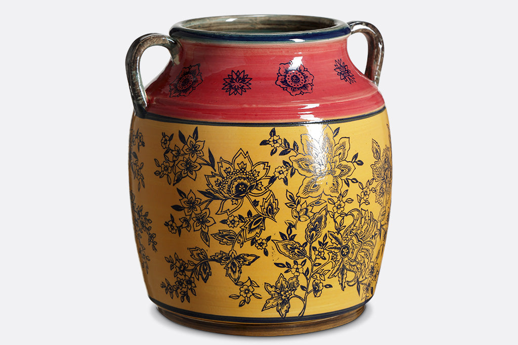 Melone e Oro Pot has dark stamped floral motif over rose and yellow ceramic glazed regions