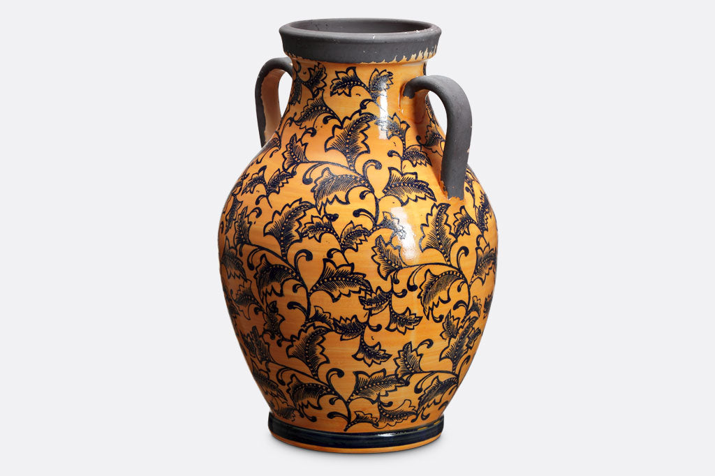 Orange-Yellow vase covered in dark leaf Mediterranean style print with two classic handles in grey that matches the rim.