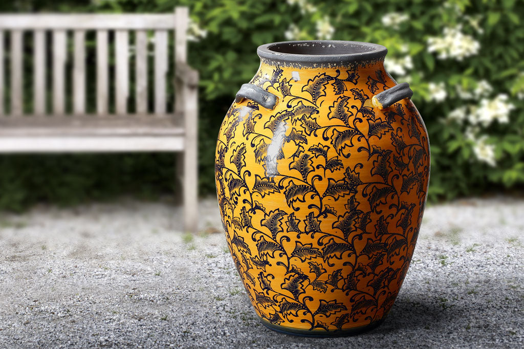 leaf and vine printed tall ceramic jar; gray handles and rim; deep orange-yellow glaze