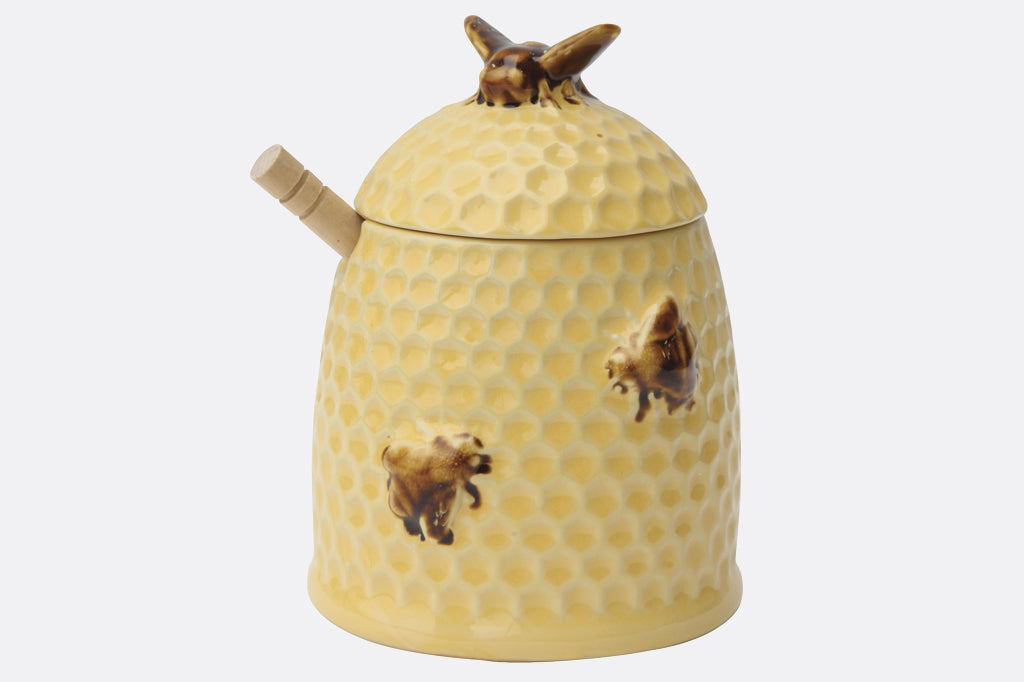 stoneware honeypot shaped like a beehive with wooden spoon