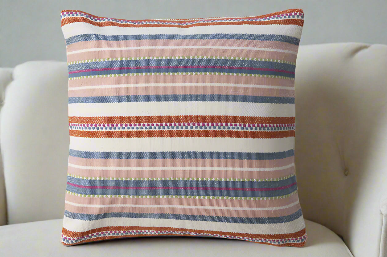 red, pink , blue and white stripped pillow with colorful stitching 