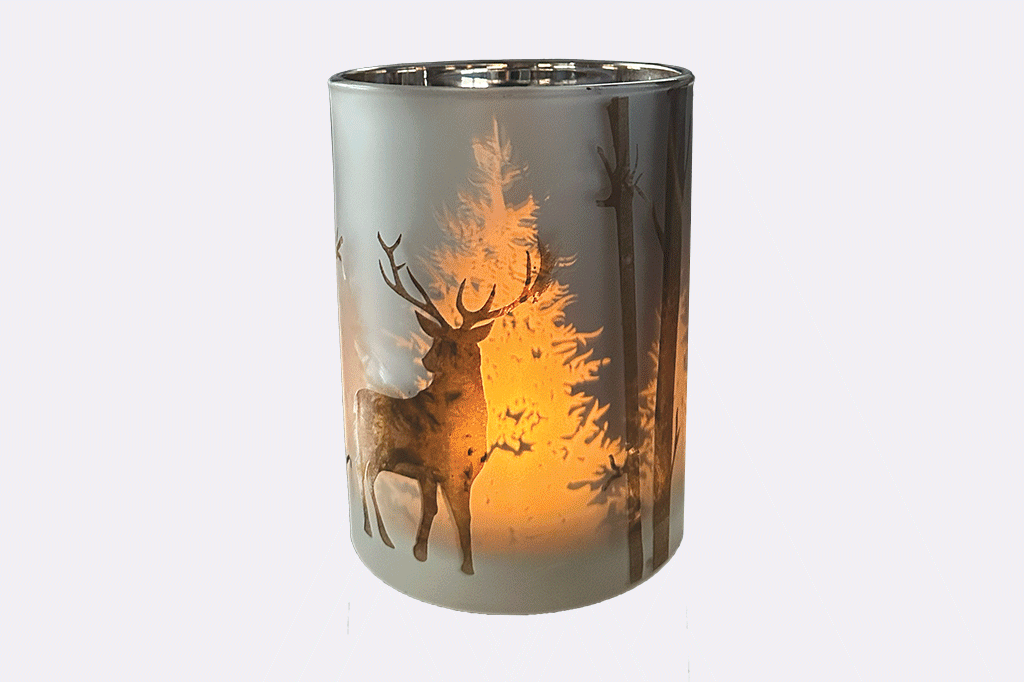Candleholder with laser-etched design of stag and trees creates a dimensional light show