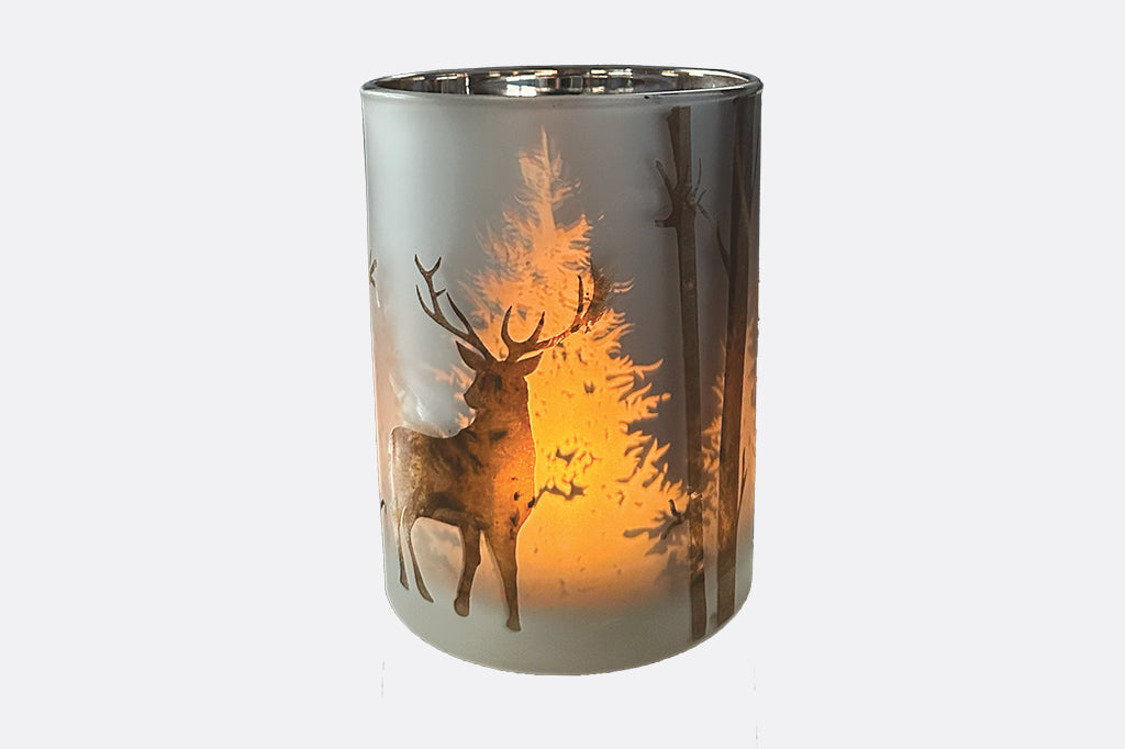 Candleholder with laser-etched design of stag and trees creates a dimensional light show