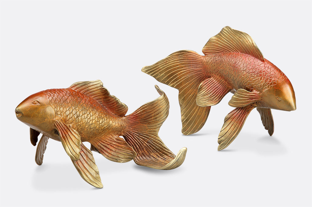 Two golden orange koi fish sculptures 
