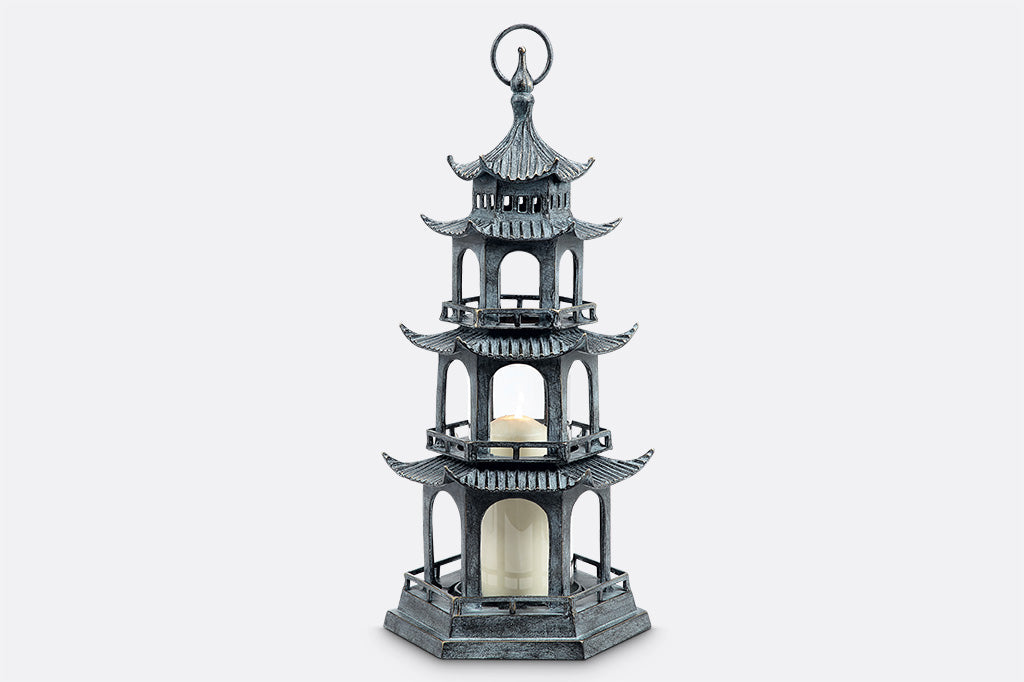 sculptural cast metal lantern shaped like Chinese pagoda holding pillar candle