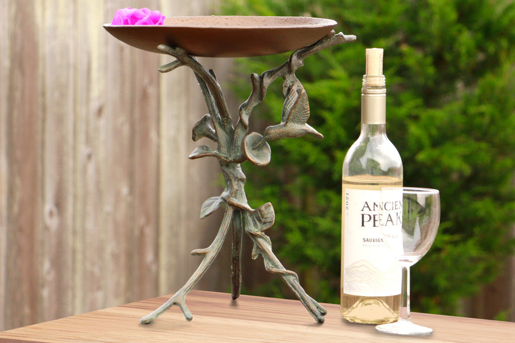 tabletop birdbath with blossoms on table with wine bottle and wine glass