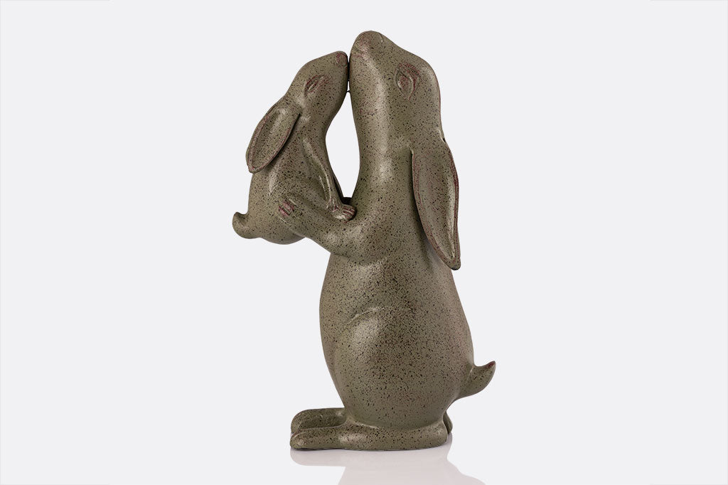 Garden sculpture of rabbit nuzzling a baby bunny, face left