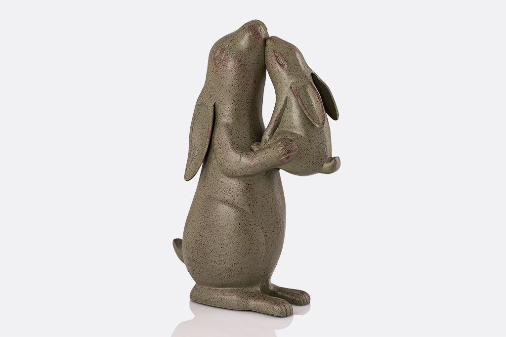 Garden sculpture of rabbit nuzzling a baby bunny, face right